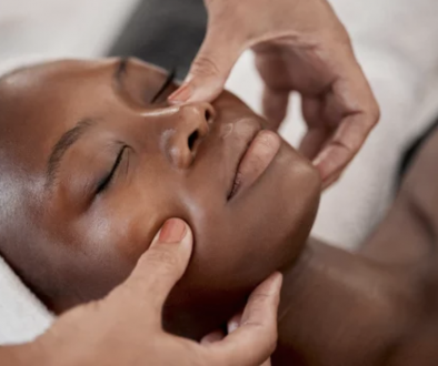 kvinna får ansiktsbehandling, händer masserar kvinnas ansikte